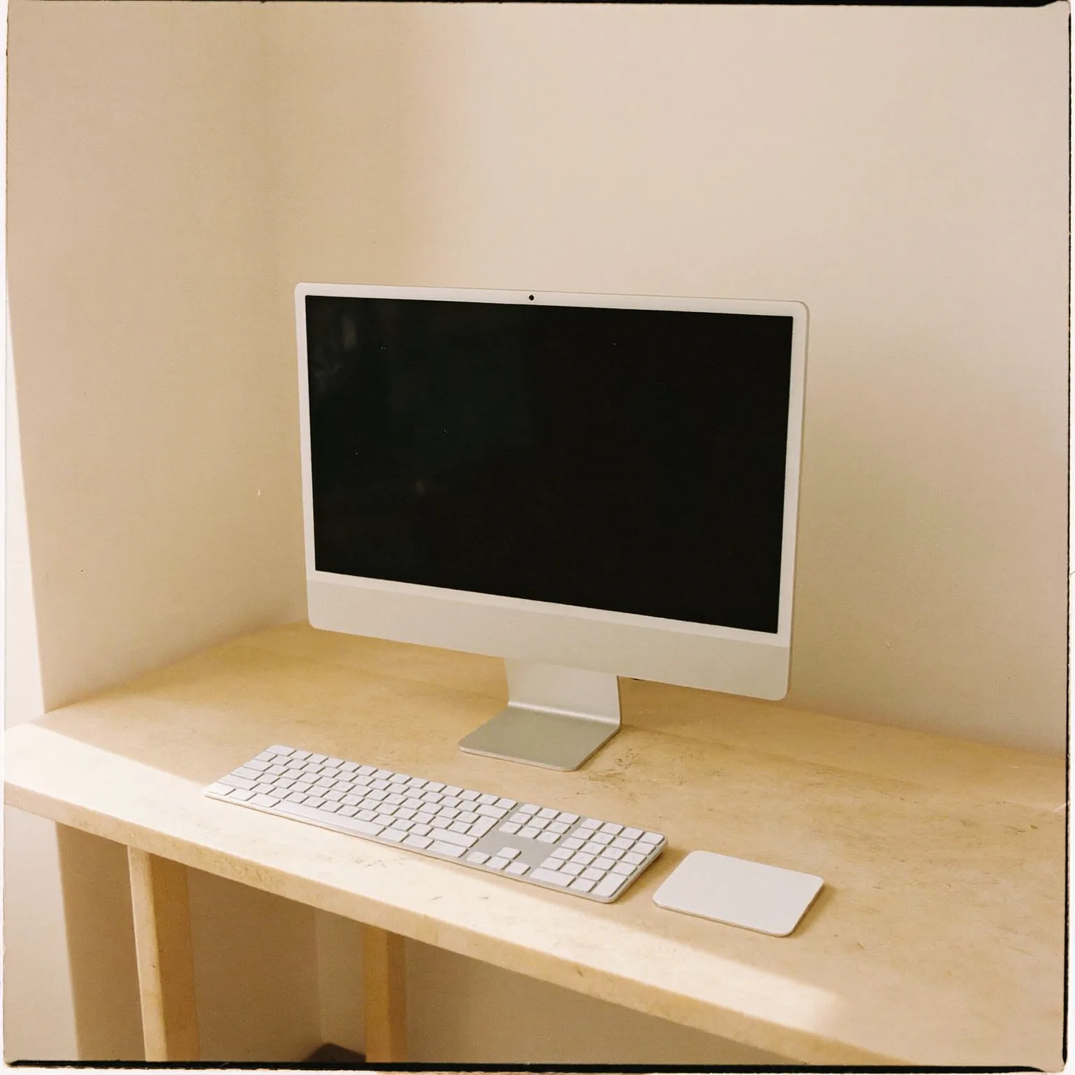 Workspace desk with an iMac, keyboard and trackpad