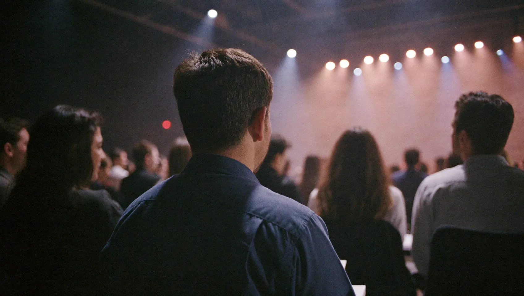 Concert audience seen from behind under stage lights